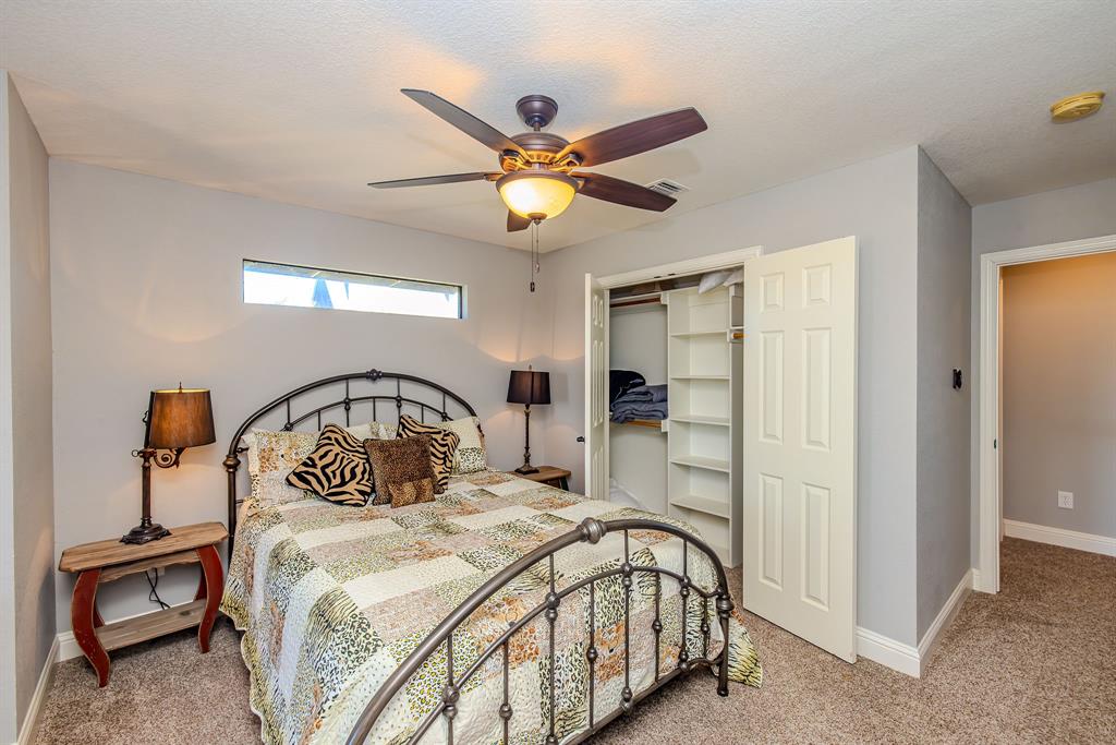 401 Frog Branch Court Graford, TX 76449 - Photo 32 of 40 a bedroom with a bed and a chandelier