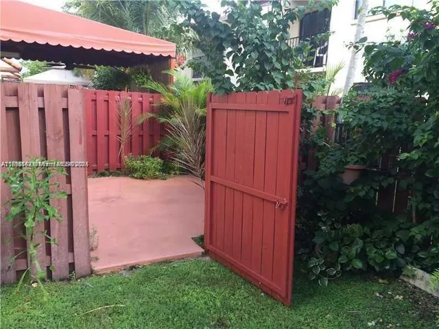 a view of a backyard with potted plants and wooden fence