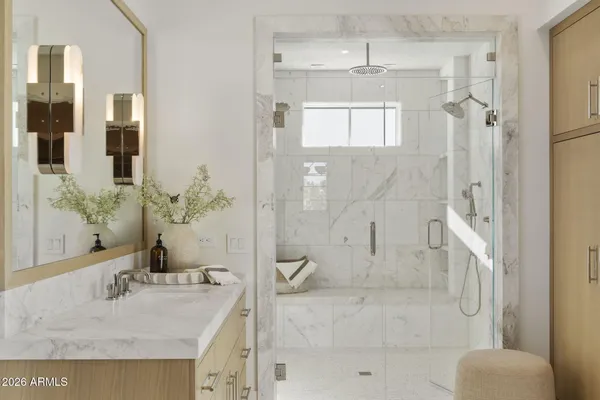 a bathroom with a granite countertop shower sink and mirror