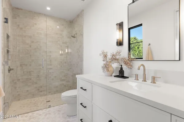 a bathroom with a sink a toilet and shower