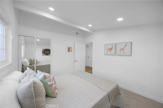 a bedroom with a bed and a painting on the wall