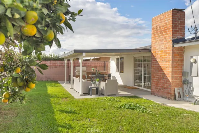 a view of a house with backyard and sitting area