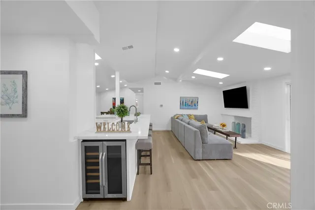 a living room with furniture a flat screen tv and kitchen view