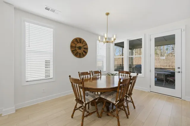 a view of a dining room and livingroom with furniture wooden floor a rug