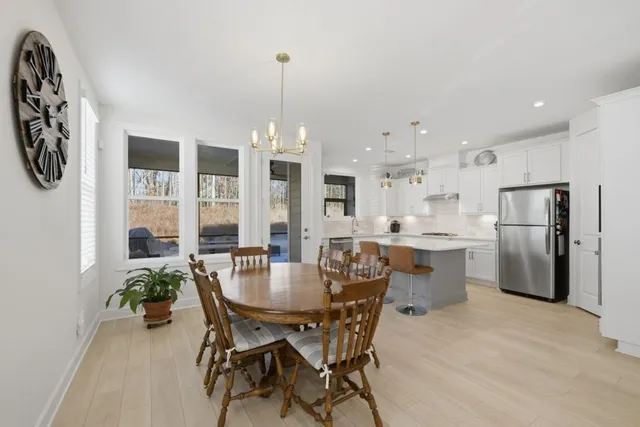 a kitchen with a sink a stove a refrigerator and white cabinets