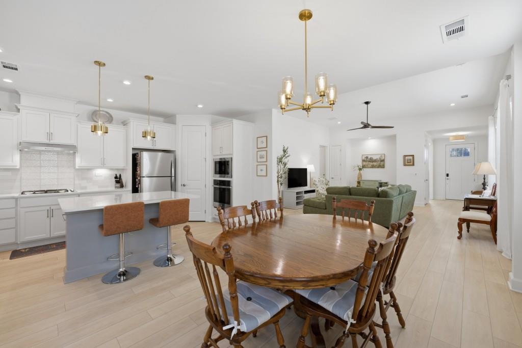 226 Geneva Way Hoschton, GA 30548 - Photo 17 of 84 a view of a dining room and livingroom with furniture wooden floor a rug