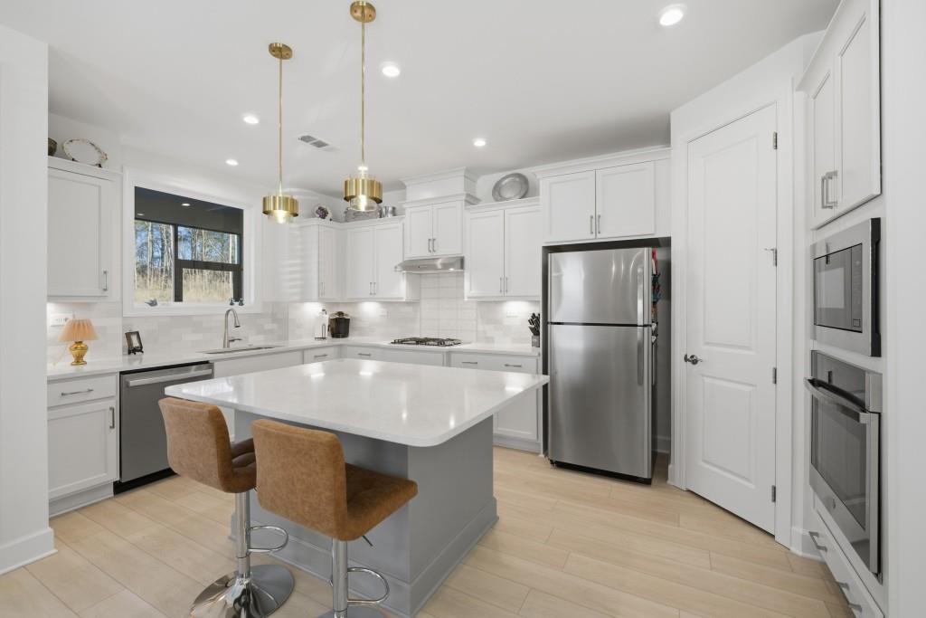 226 Geneva Way Hoschton, GA 30548 - Photo 18 of 84 a kitchen with refrigerator cabinets and a sink