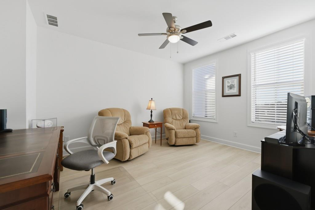226 Geneva Way Hoschton, GA 30548 - Photo 23 of 84 a living room with furniture and a flat screen tv