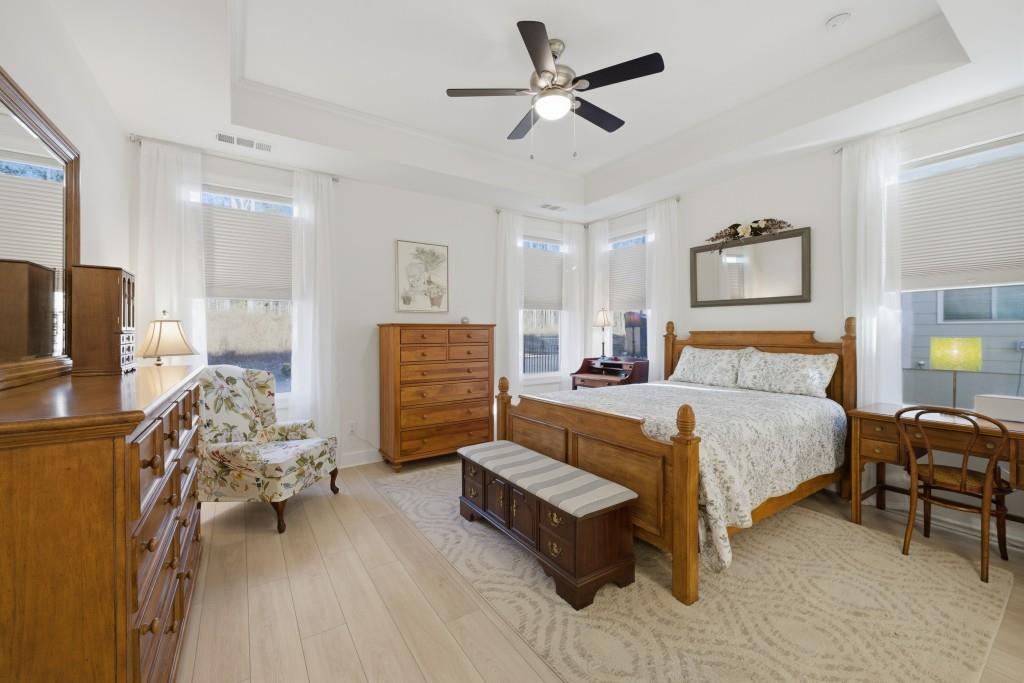 226 Geneva Way Hoschton, GA 30548 - Photo 27 of 84 a spacious bedroom with a bed and a chandelier