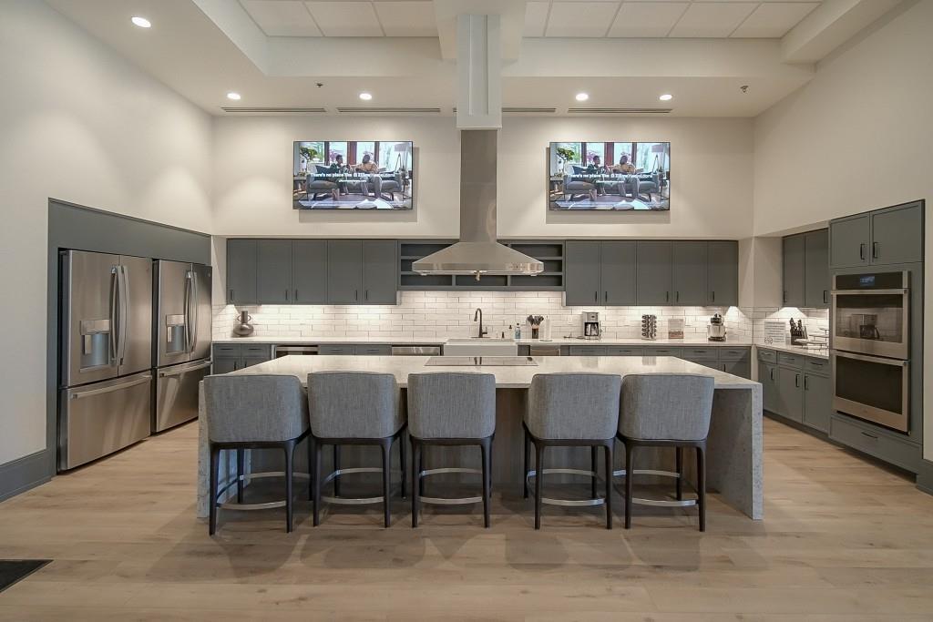226 Geneva Way Hoschton, GA 30548 - Photo 44 of 84 a kitchen with stainless steel appliances granite countertop a dining table and chairs