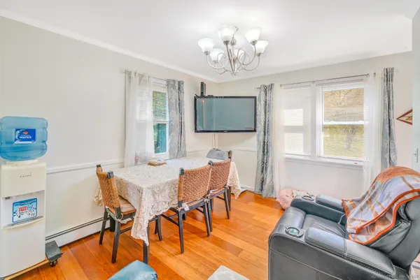 a view of a dining room with furniture a chandelier and wooden floor