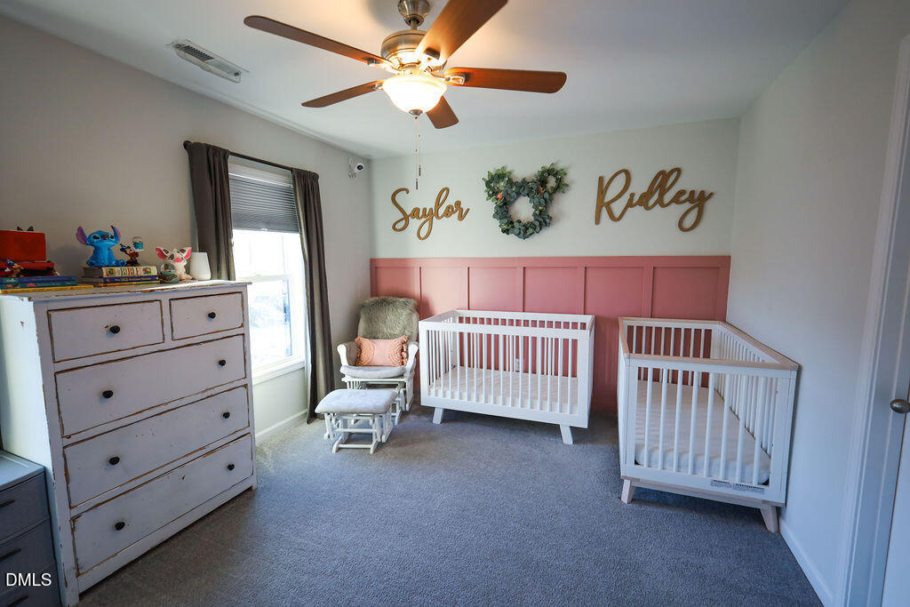 230 South Raleigh Street Angier, NC 27501 - Photo 32 of 38 a bedroom with a bed and a chandelier
