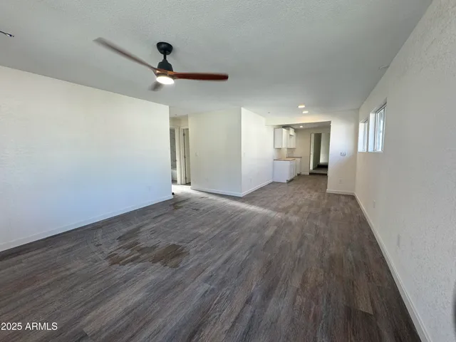 a view of a livingroom with wooden floor and a ceiling fan