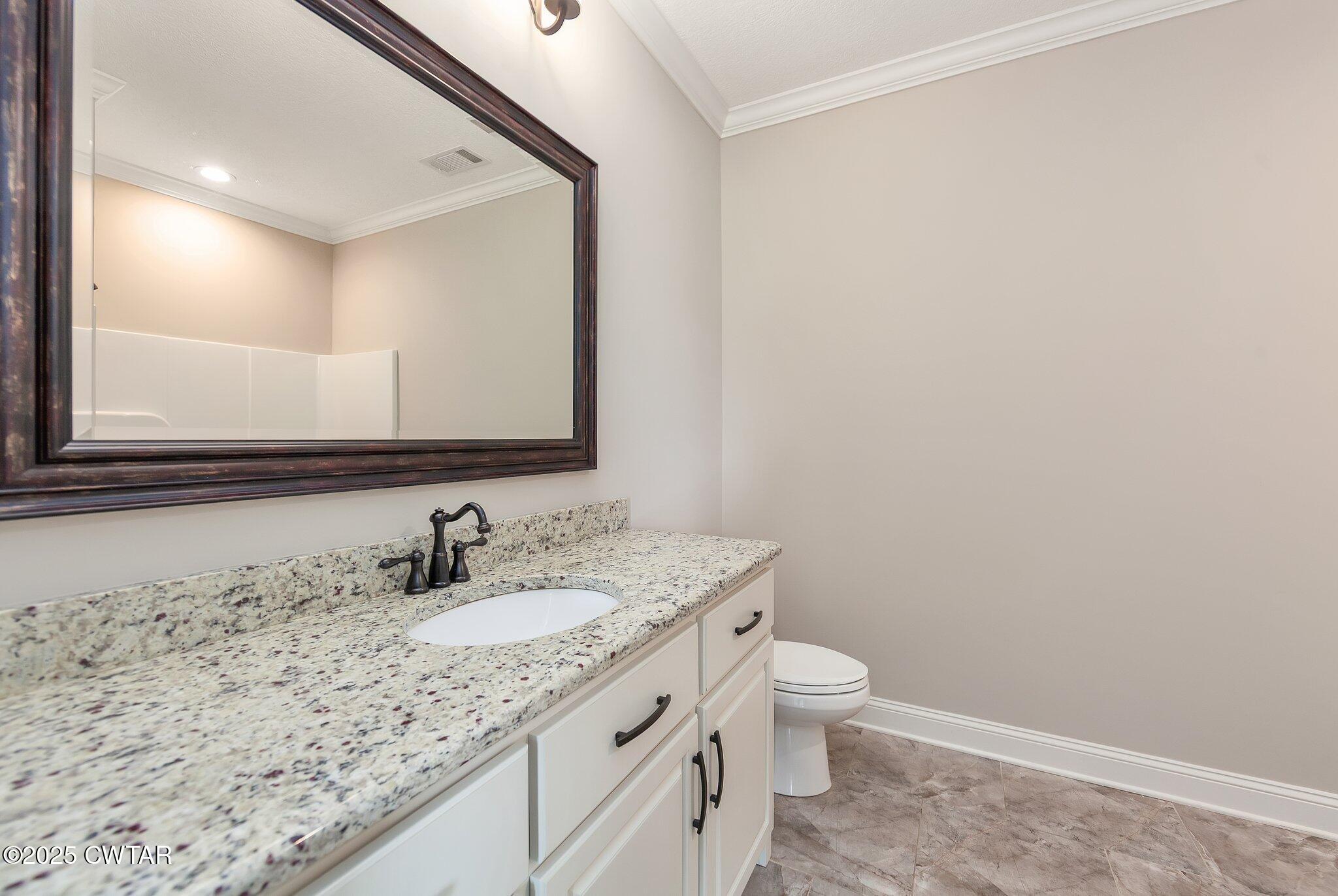 42 Cheddleton Cove Jackson, TN 38305 - Photo 20 of 37 a bathroom with a granite countertop sink a toilet and a mirror