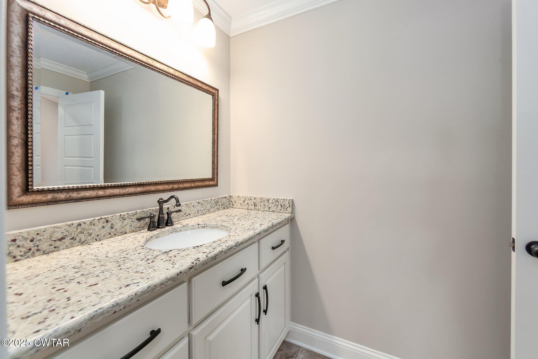42 Cheddleton Cove Jackson, TN 38305 - Photo 26 of 37 a bathroom with a granite countertop sink and a mirror