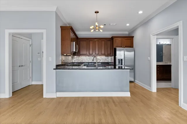 a view of kitchen with granite countertop cabinets and refrigerator