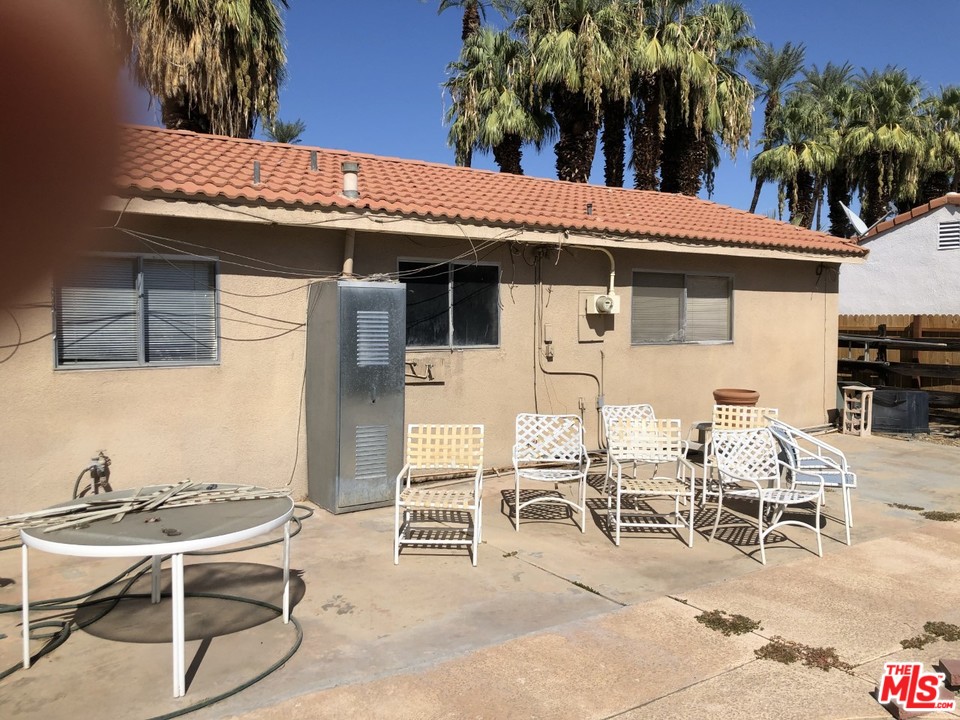 70071 Cobb Road Rancho Mirage, CA 92270 - Photo 10 of 22 a view of a patio with table and chairs with wooden fence and plants