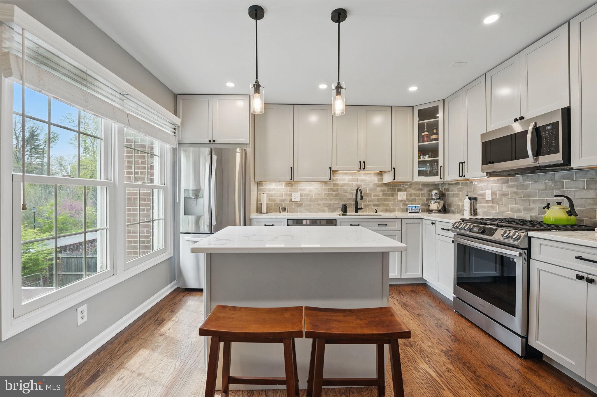 8333 Wickham Road Springfield, VA 22152 - Photo 16 of 54 a kitchen with kitchen island a stove a sink and a refrigerator