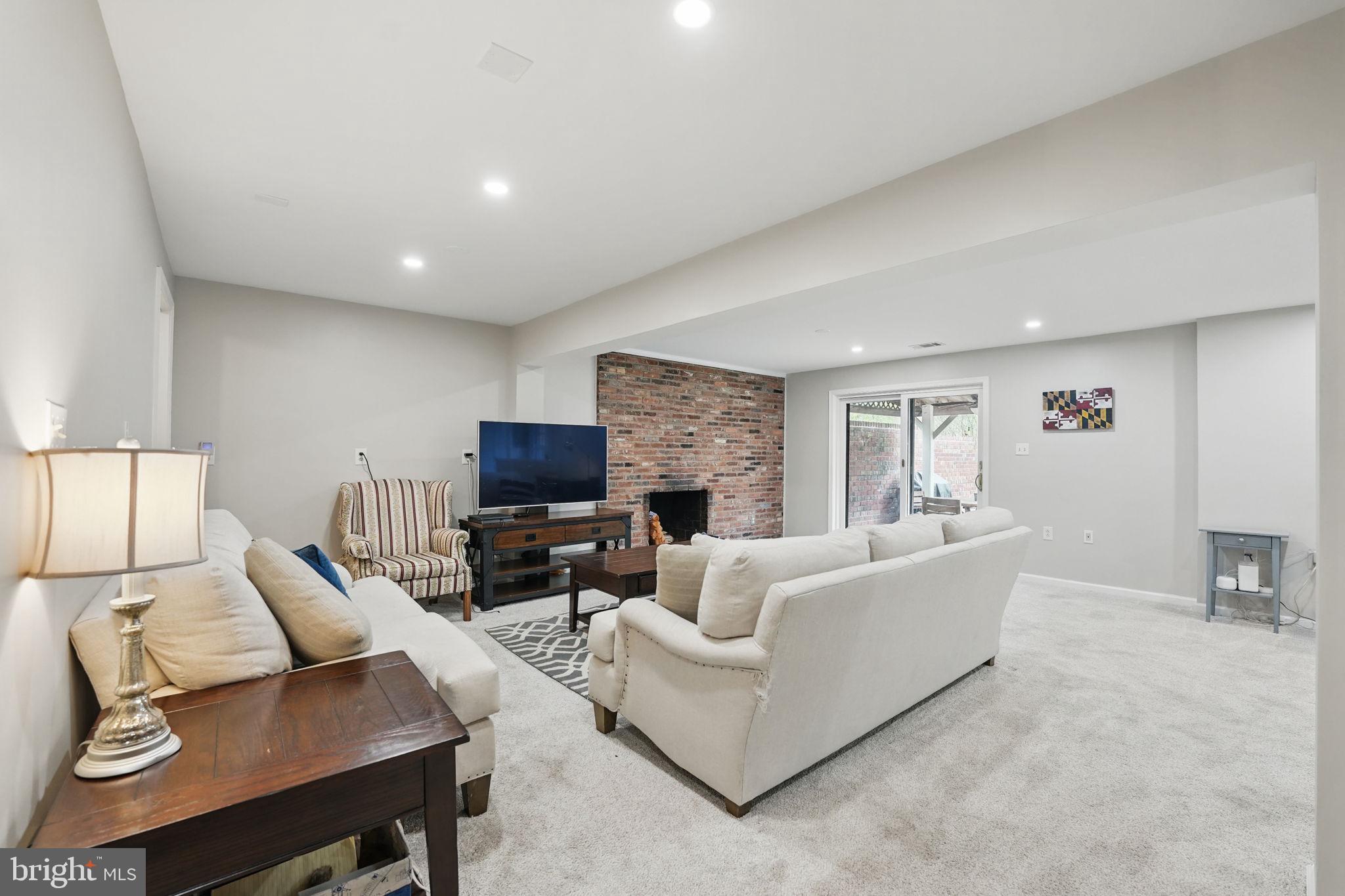 8333 Wickham Road Springfield, VA 22152 - Photo 38 of 54 a living room with furniture a fireplace and a flat screen tv