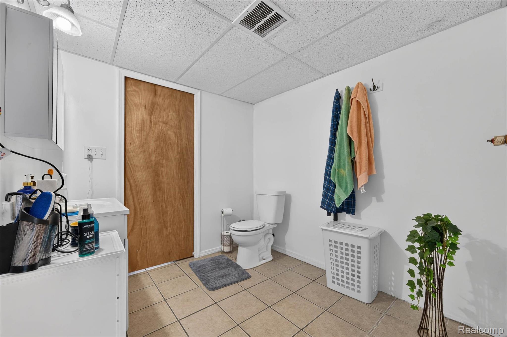 46362 Springhill Drive Utica, MI 48317 - Photo 36 of 59 Utility room featuring a toilet, tile flooring, and a drop ceiling
