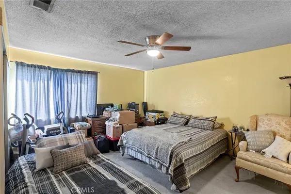 a spacious bedroom with a bed and a chandelier
