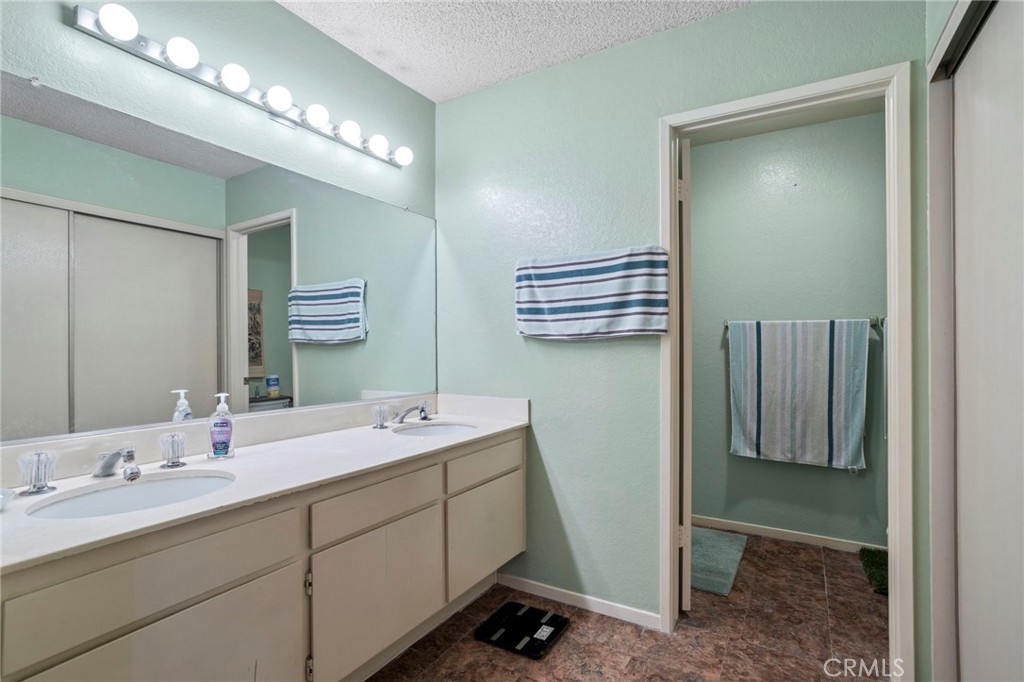7823 Ramona Avenue Rancho Cucamonga, CA 91730 - Photo 14 of 18 a bathroom with a double vanity sink and mirror