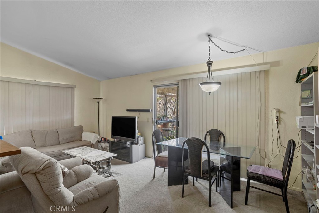 7823 Ramona Avenue Rancho Cucamonga, CA 91730 - Photo 6 of 18 a living room with furniture a flat screen tv and a fireplace