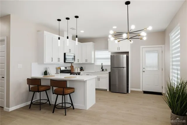 a kitchen with refrigerator a sink and chairs