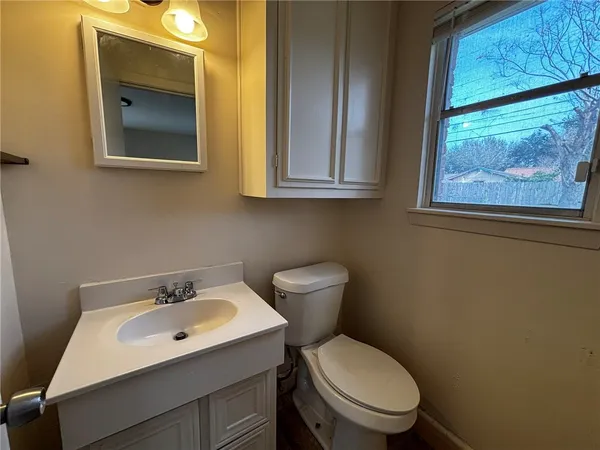 a bathroom with a toilet sink and mirror