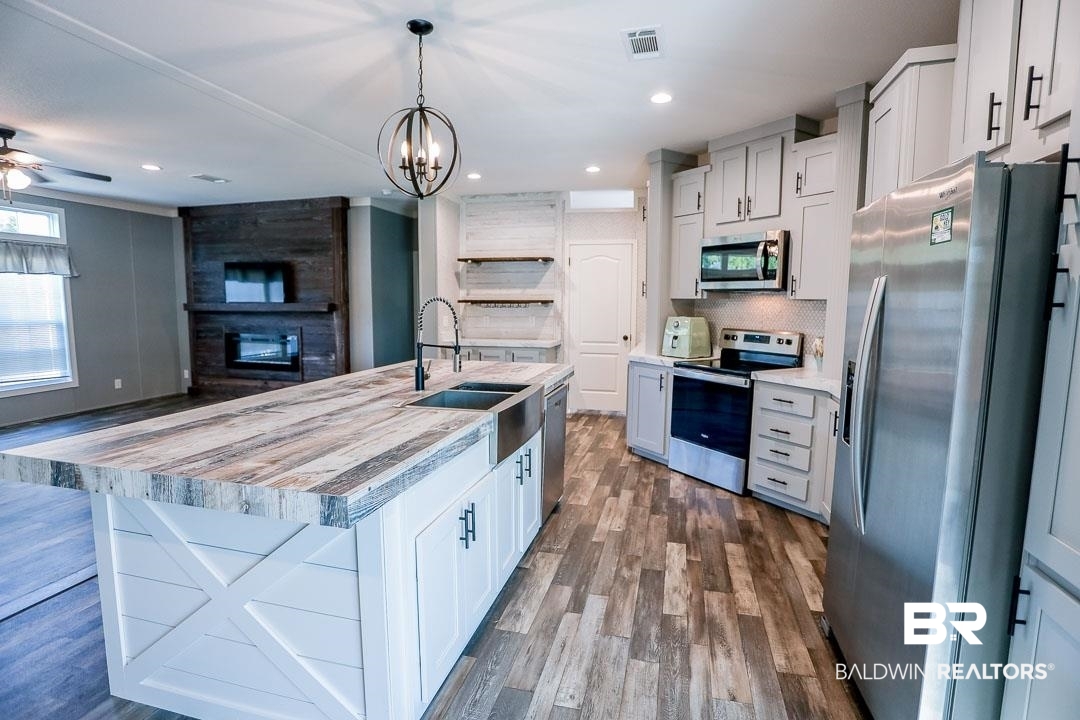 19180 Horseshoe Circle Seminole, AL 36574 - Photo 9 of 38 Kitchen with appliances with stainless steel finishes, dark wood-style flooring, white cabinetry, hanging light fixtures, and recessed lighting