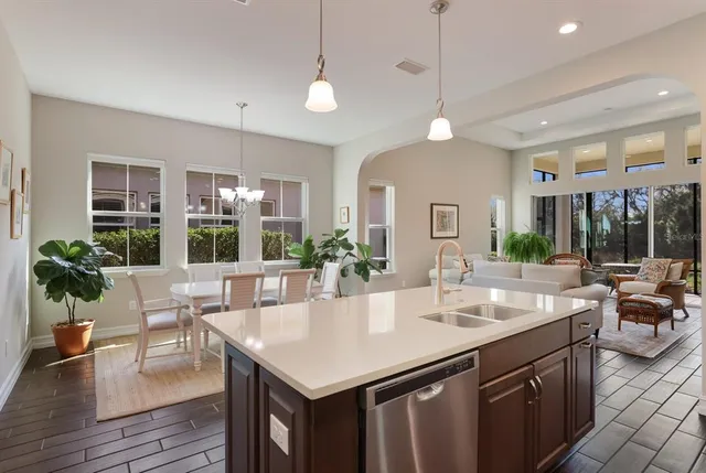 a living room with furniture and a dining table with kitchen view