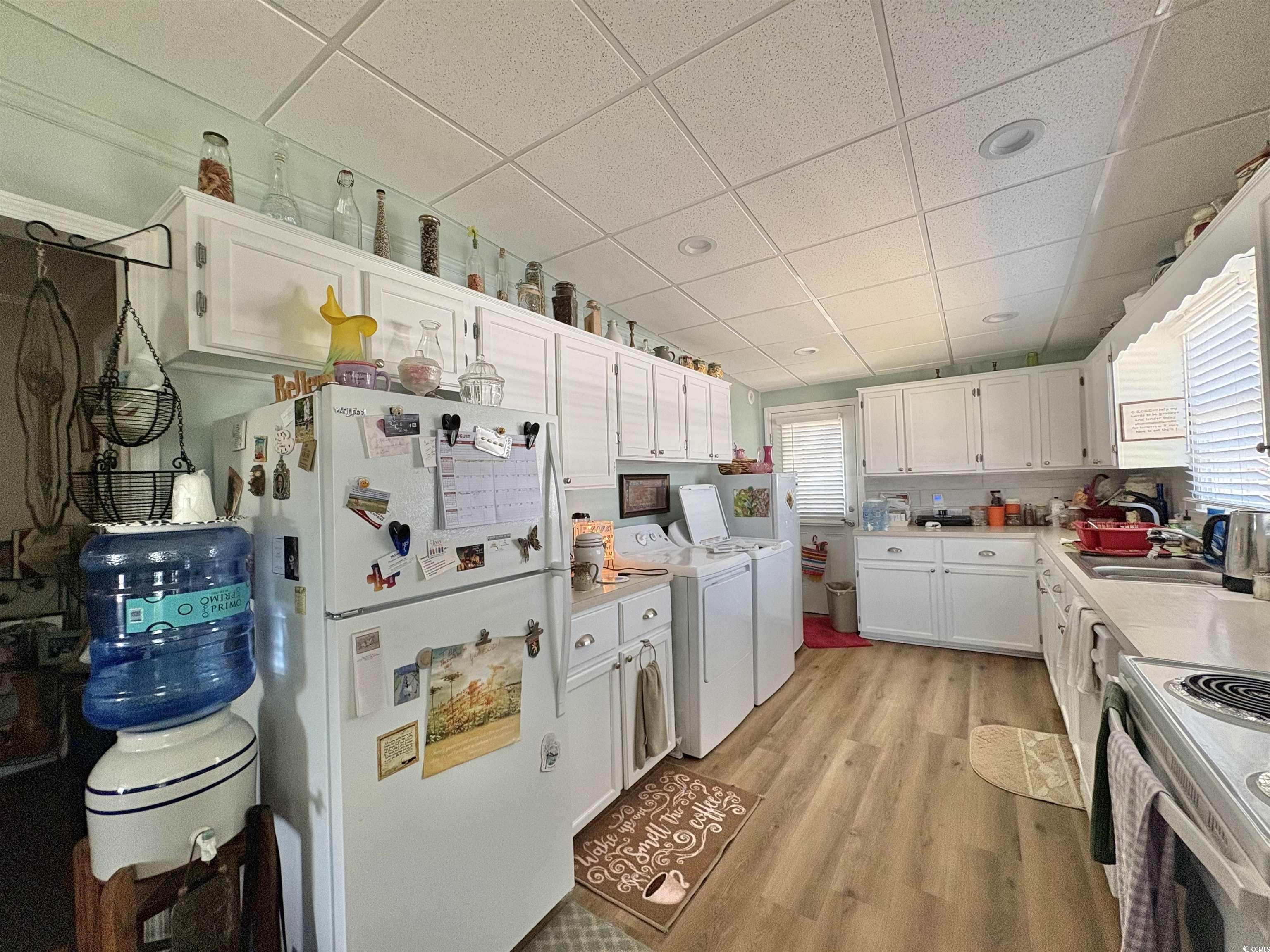 520-526 Boundary Avenue Murrells Inlet, SC 29576 - Photo 15 of 38 Kitchen featuring a paneled ceiling, white cabinetry, white appliances, light wood-style flooring, and light countertops