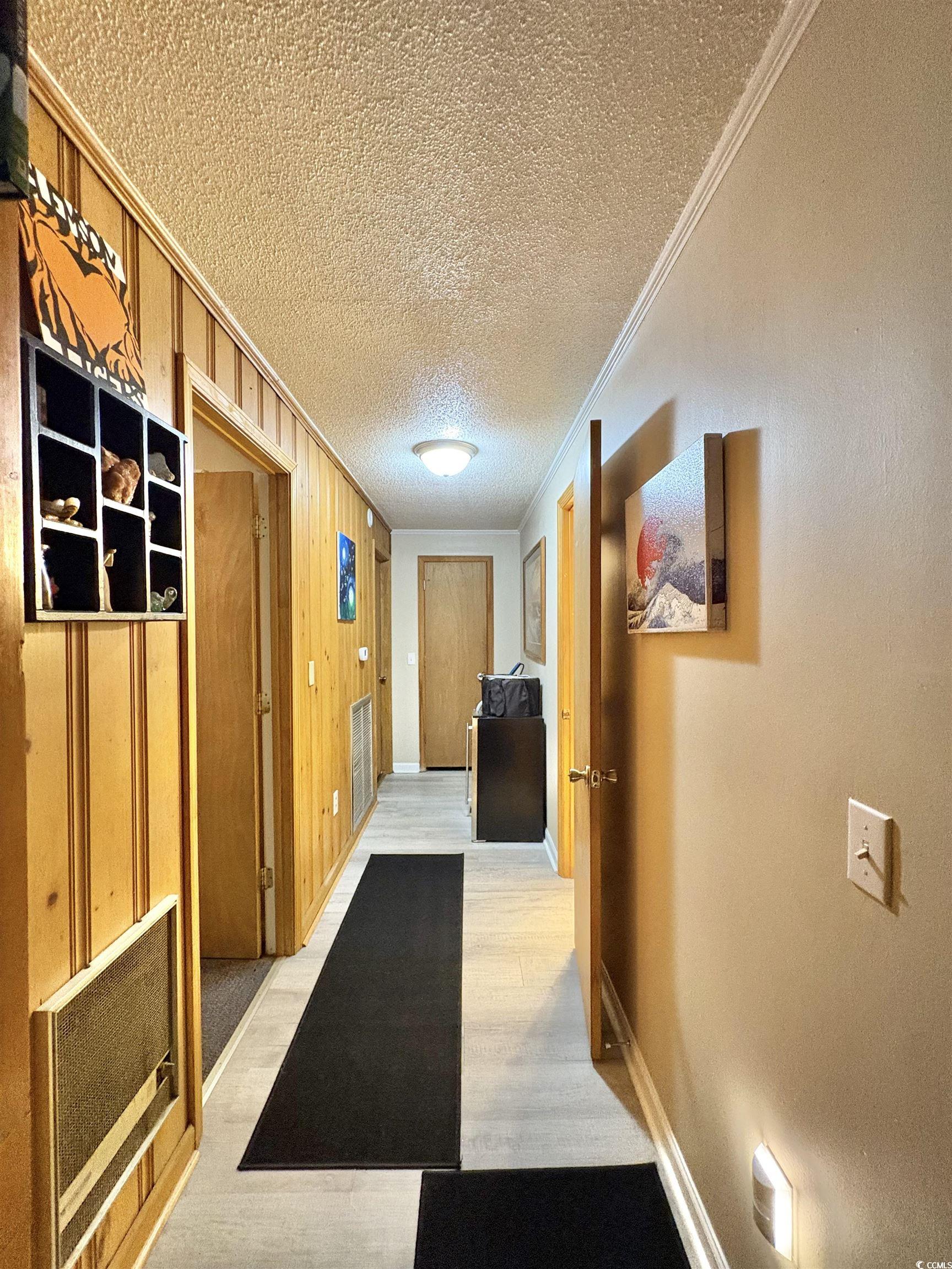 520-526 Boundary Avenue Murrells Inlet, SC 29576 - Photo 25 of 38 Hall featuring wooden walls, ornamental molding, and a textured ceiling