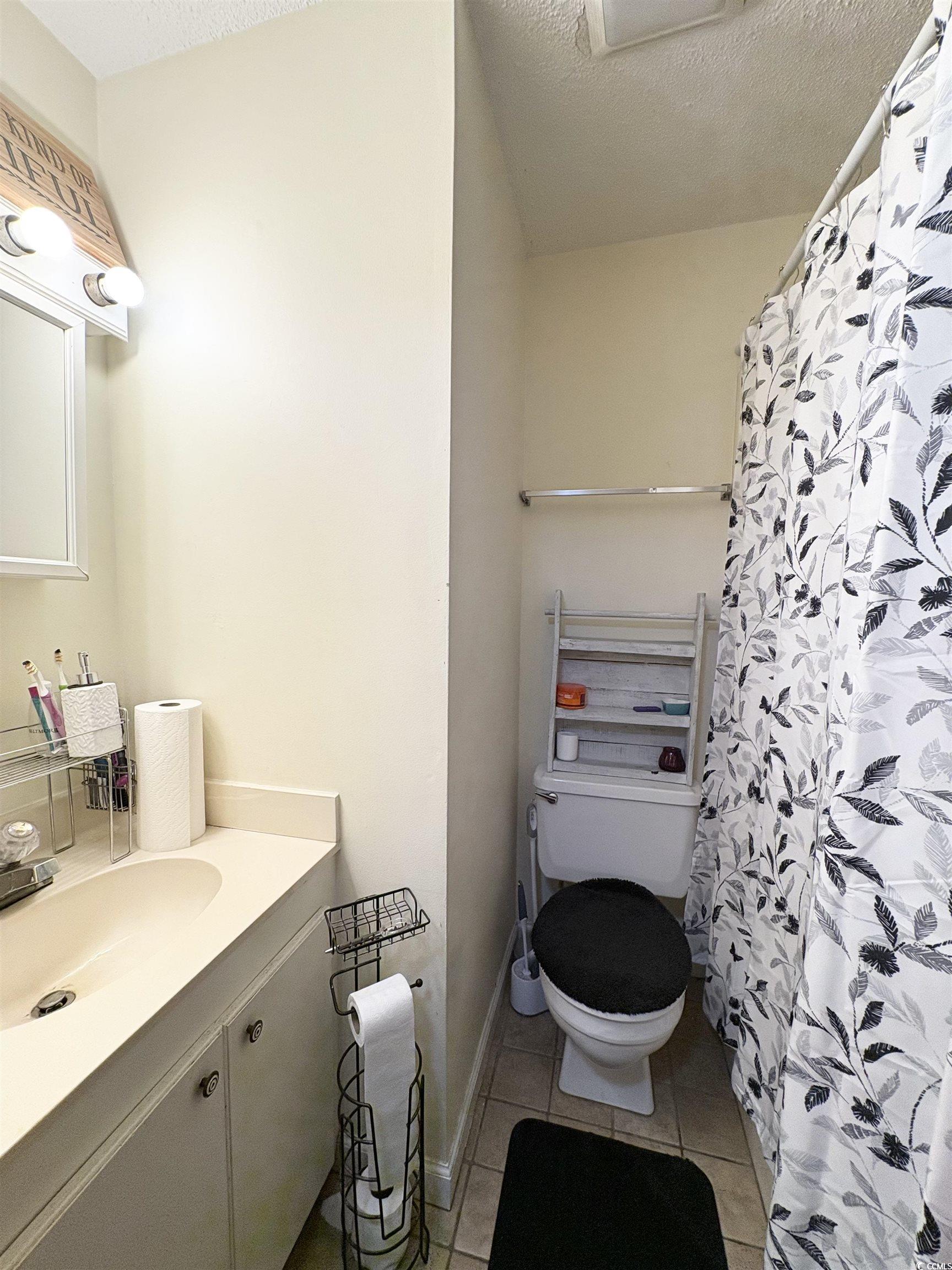 520-526 Boundary Avenue Murrells Inlet, SC 29576 - Photo 29 of 38 Bathroom with vanity, a textured ceiling, light tile patterned floors, and a shower with curtain