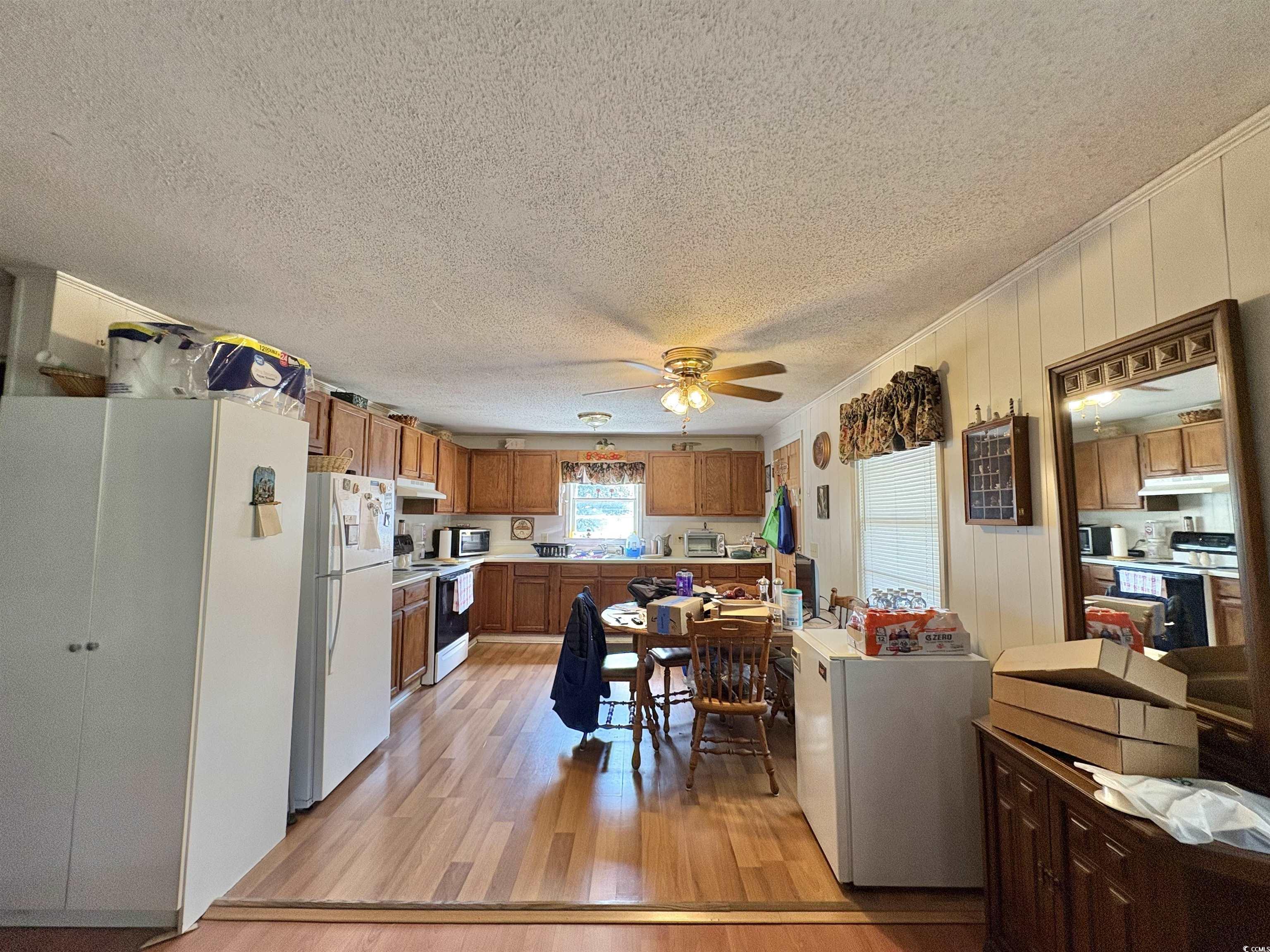 520-526 Boundary Avenue Murrells Inlet, SC 29576 - Photo 30 of 38 Kitchen with brown cabinetry, light wood-style floors, white appliances, a ceiling fan, and light countertops