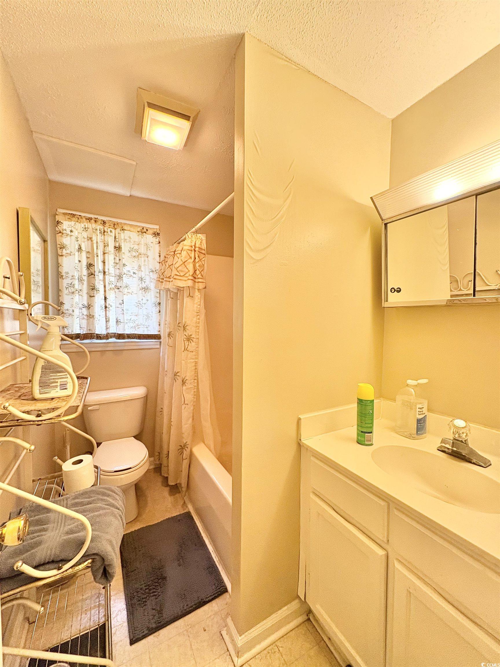 520-526 Boundary Avenue Murrells Inlet, SC 29576 - Photo 33 of 38 Full bathroom featuring a textured ceiling, shower / tub combo, vanity, and light tile patterned flooring
