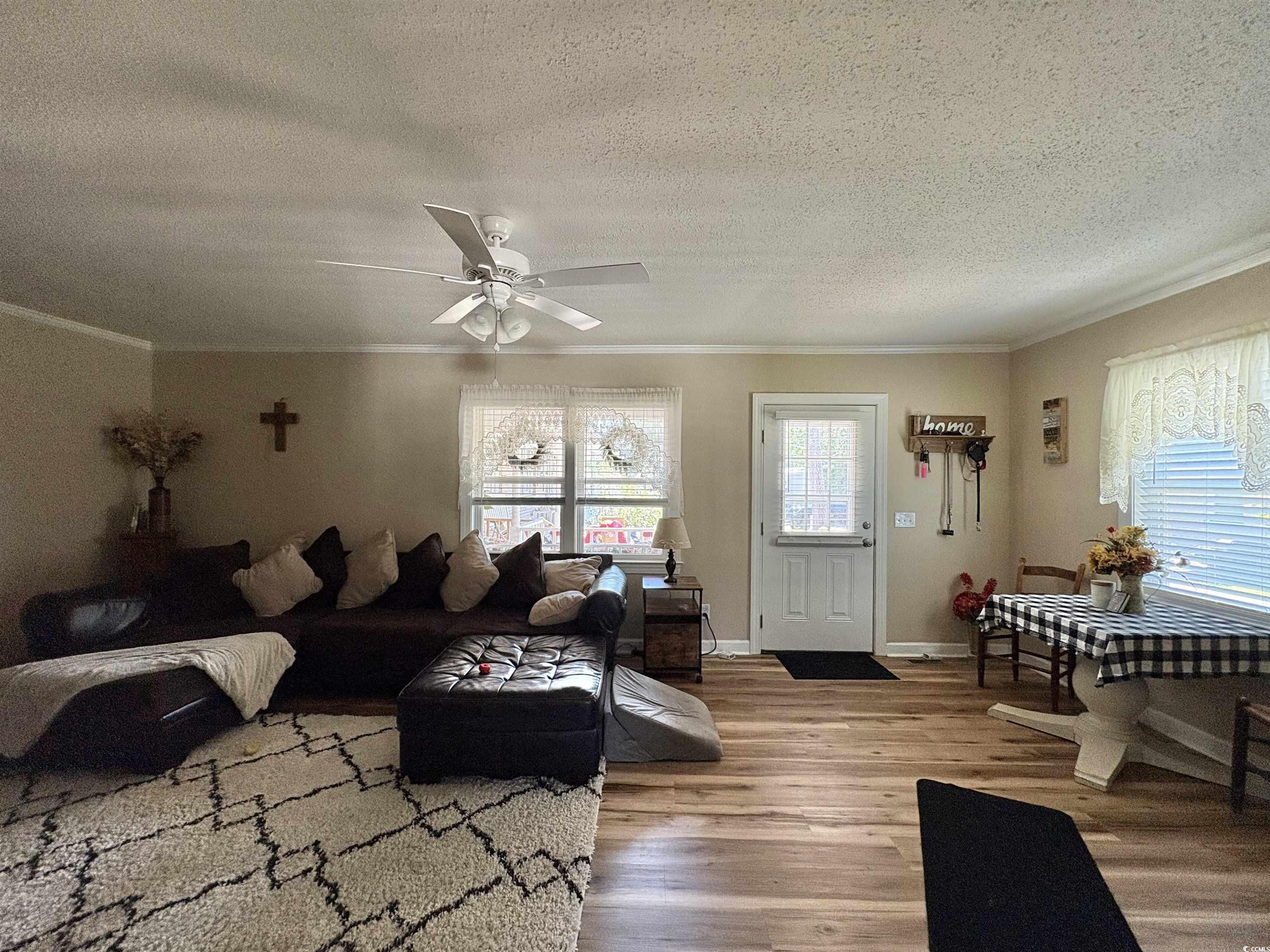 520-526 Boundary Avenue Murrells Inlet, SC 29576 - Photo 7 of 38 Living room with a textured ceiling, wood finished floors, ornamental molding, and ceiling fan