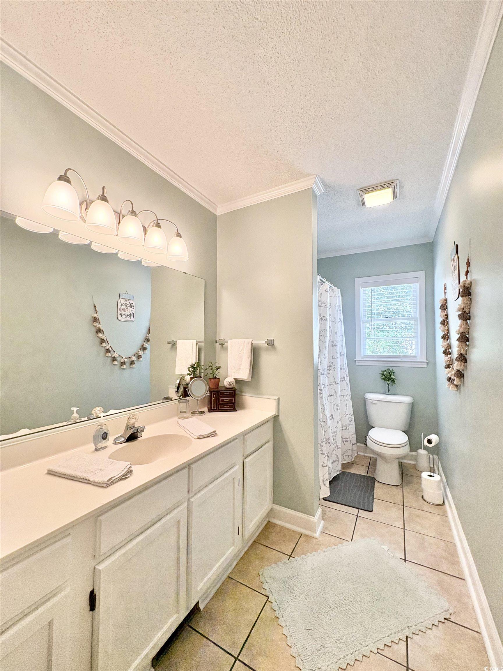 520-526 Boundary Avenue Murrells Inlet, SC 29576 - Photo 9 of 38 Full bath with a textured ceiling, light tile patterned floors, ornamental molding, vanity, and a shower with curtain