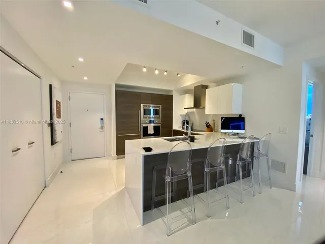 a large kitchen with kitchen island a sink stainless steel appliances and cabinets
