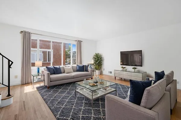 a living room with furniture a flat screen tv and a table