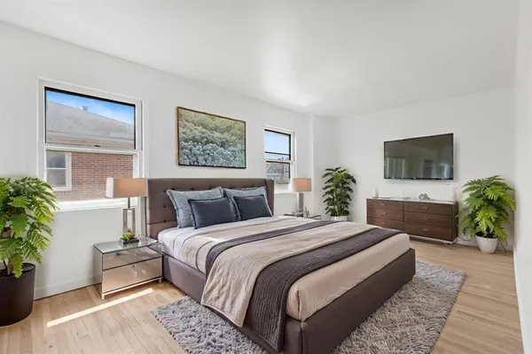 a bedroom with bed and a potted plant