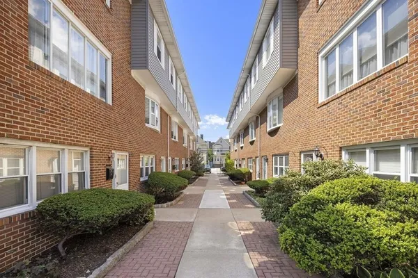 a view of a brick building next to a big yard