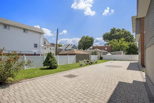 a view of a house with a yard and potted plants