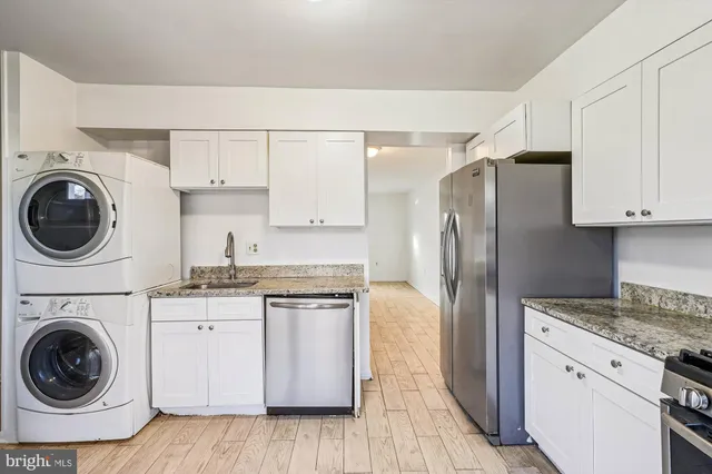 a kitchen with cabinets a washer and dryer