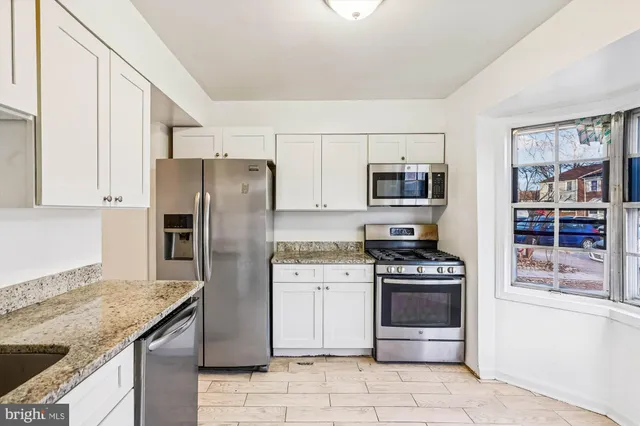 a kitchen with stainless steel appliances granite countertop a refrigerator stove and oven