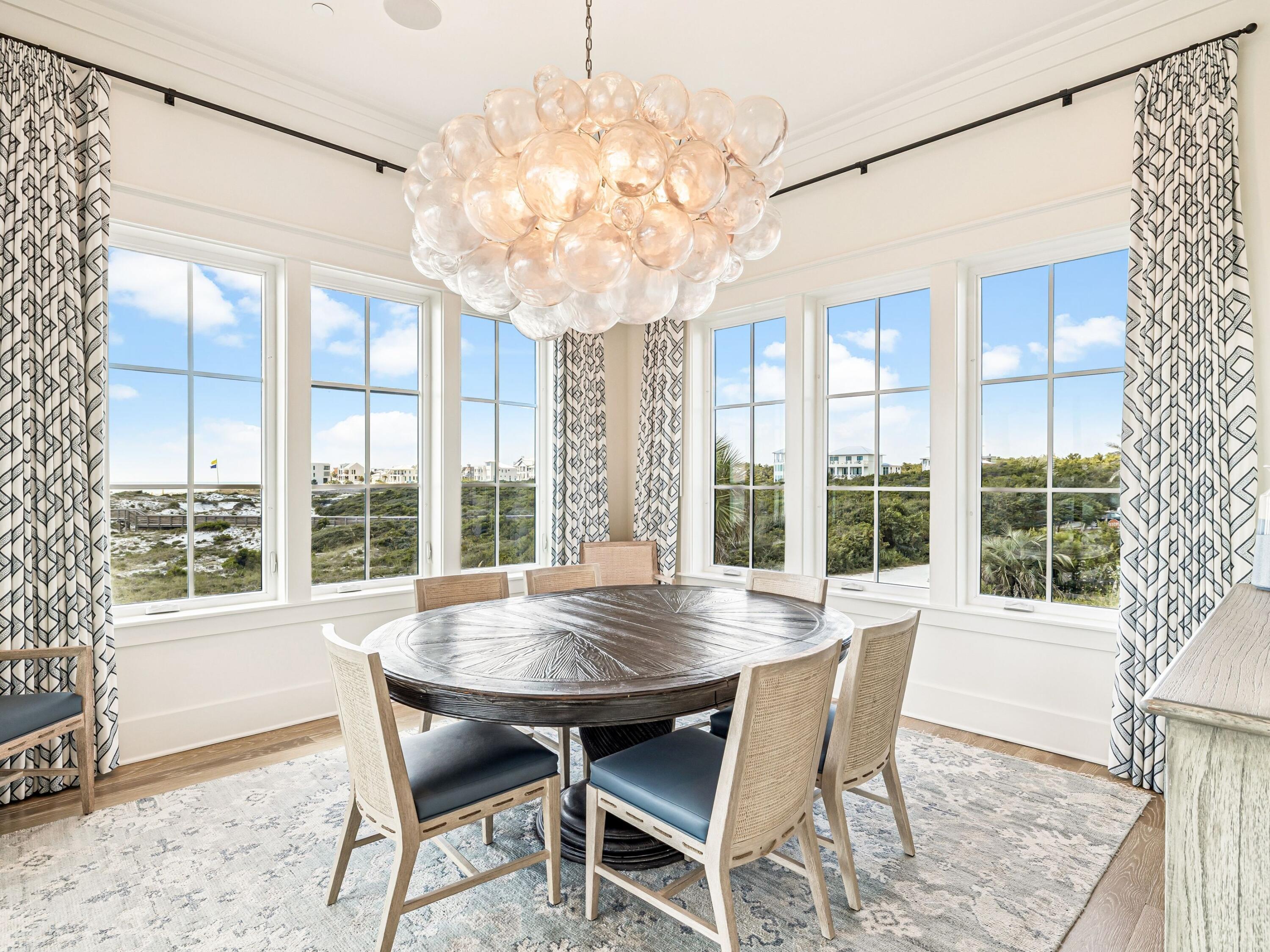 91 Emerald Cove Lane North Inlet Beach, FL 32461 - Photo 24 of 53 a view of a dining room with furniture large windows and wooden floor