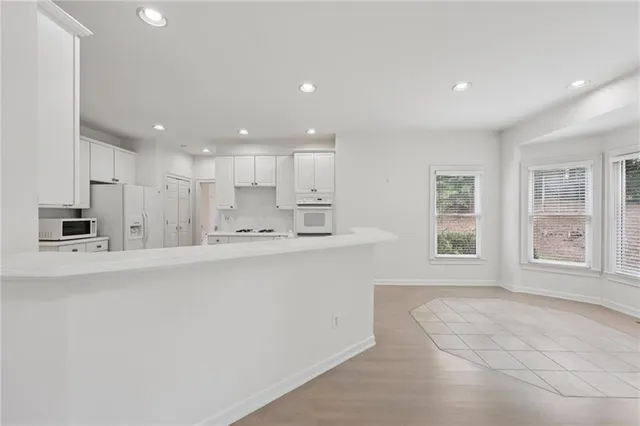 a kitchen with white cabinets and white appliances
