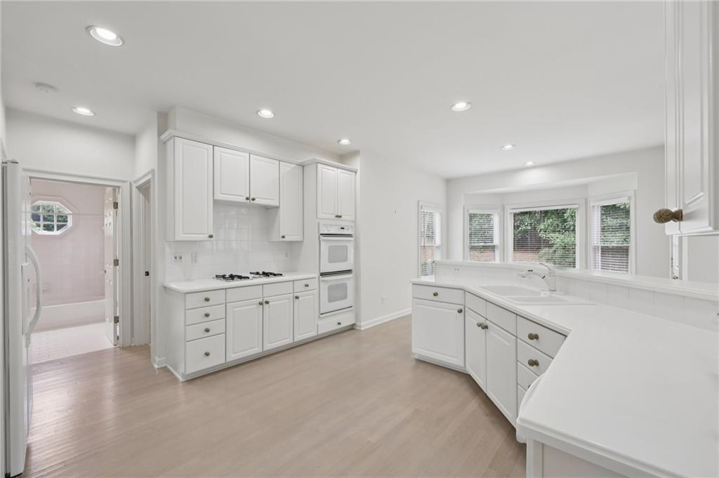 3540 Hickory Branch Trail Suwanee, GA 30024 - Photo 24 of 69 a large white kitchen with granite countertop a sink a window and stainless steel appliances
