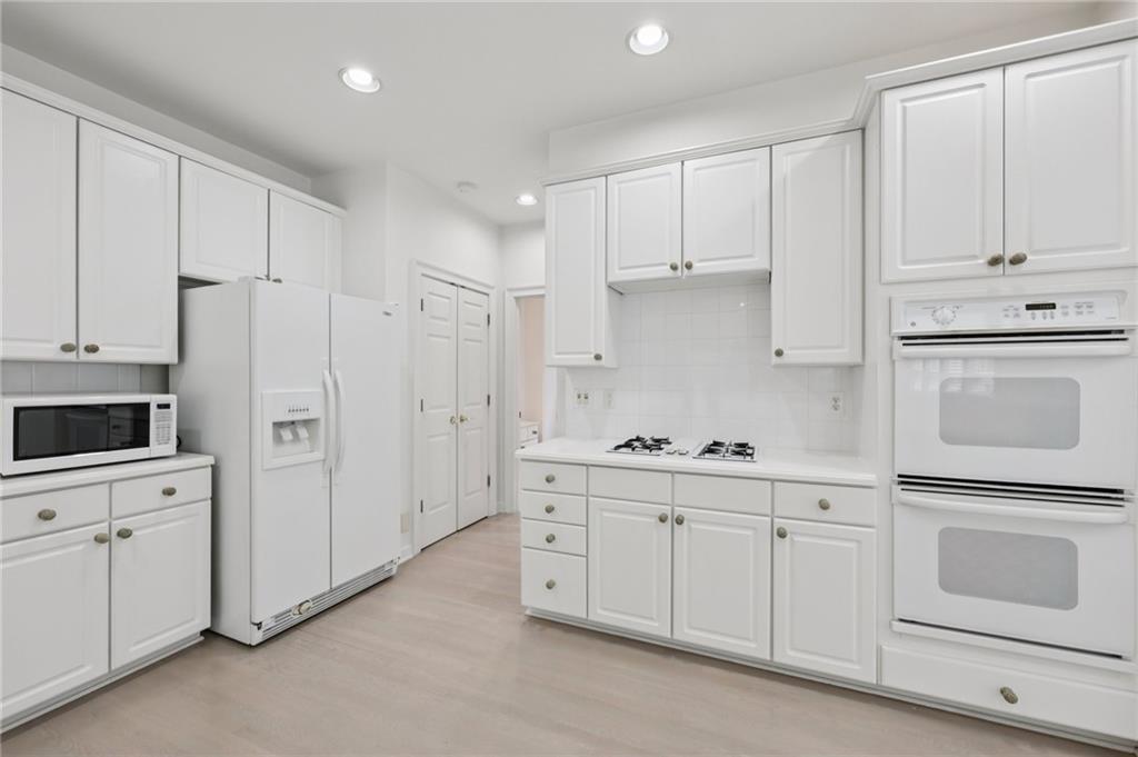 3540 Hickory Branch Trail Suwanee, GA 30024 - Photo 25 of 69 a kitchen with white cabinets and white appliances