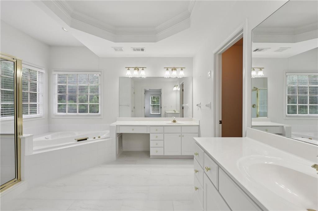 3540 Hickory Branch Trail Suwanee, GA 30024 - Photo 39 of 69 a large bathroom with a double vanity sink a mirror and a bathtub